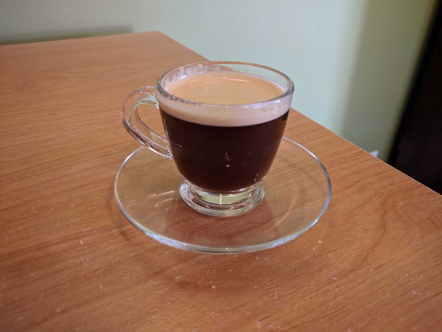 Espresso shot in clear glass with coaster