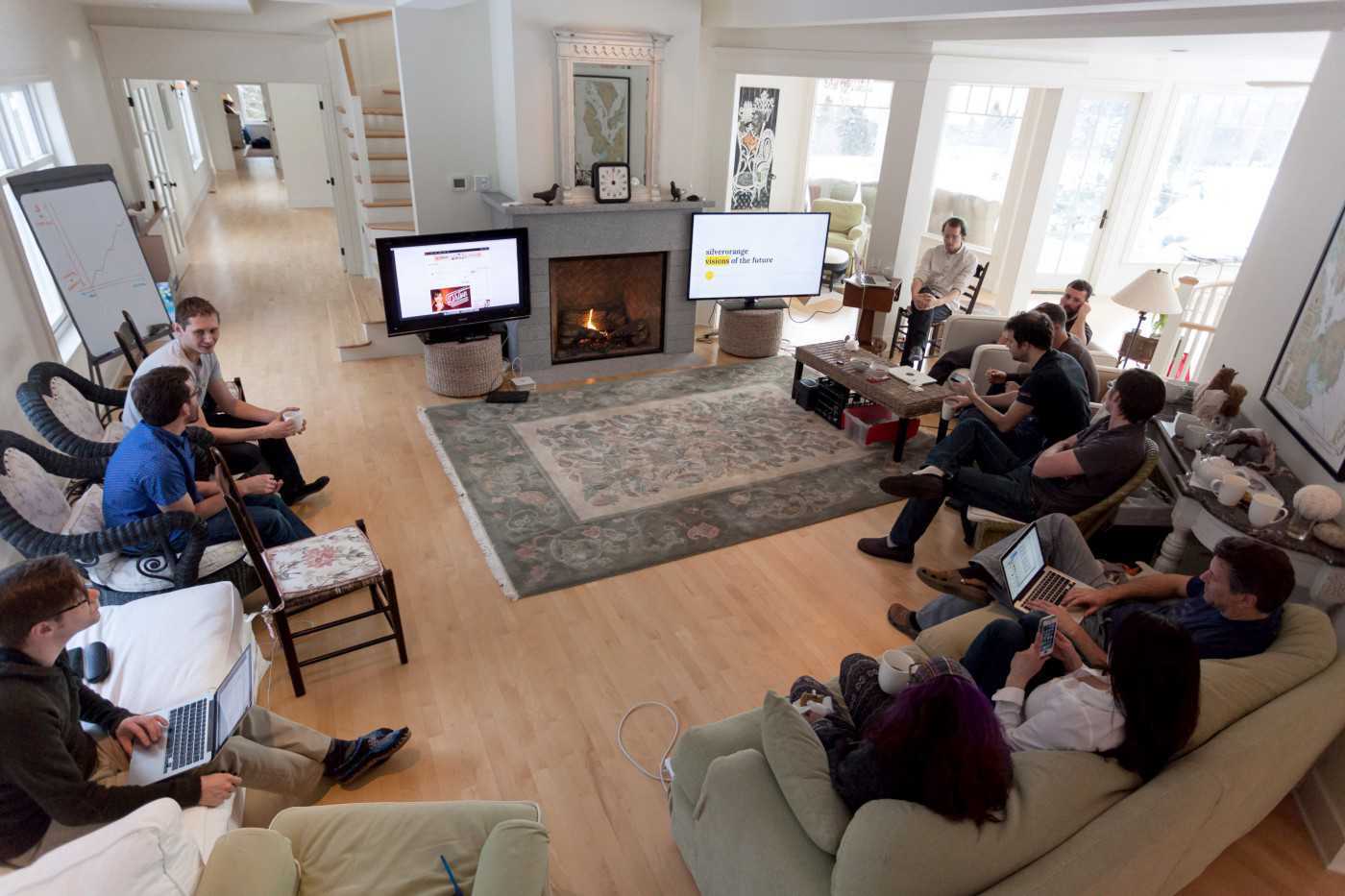 Group sitting around a room with TV screens