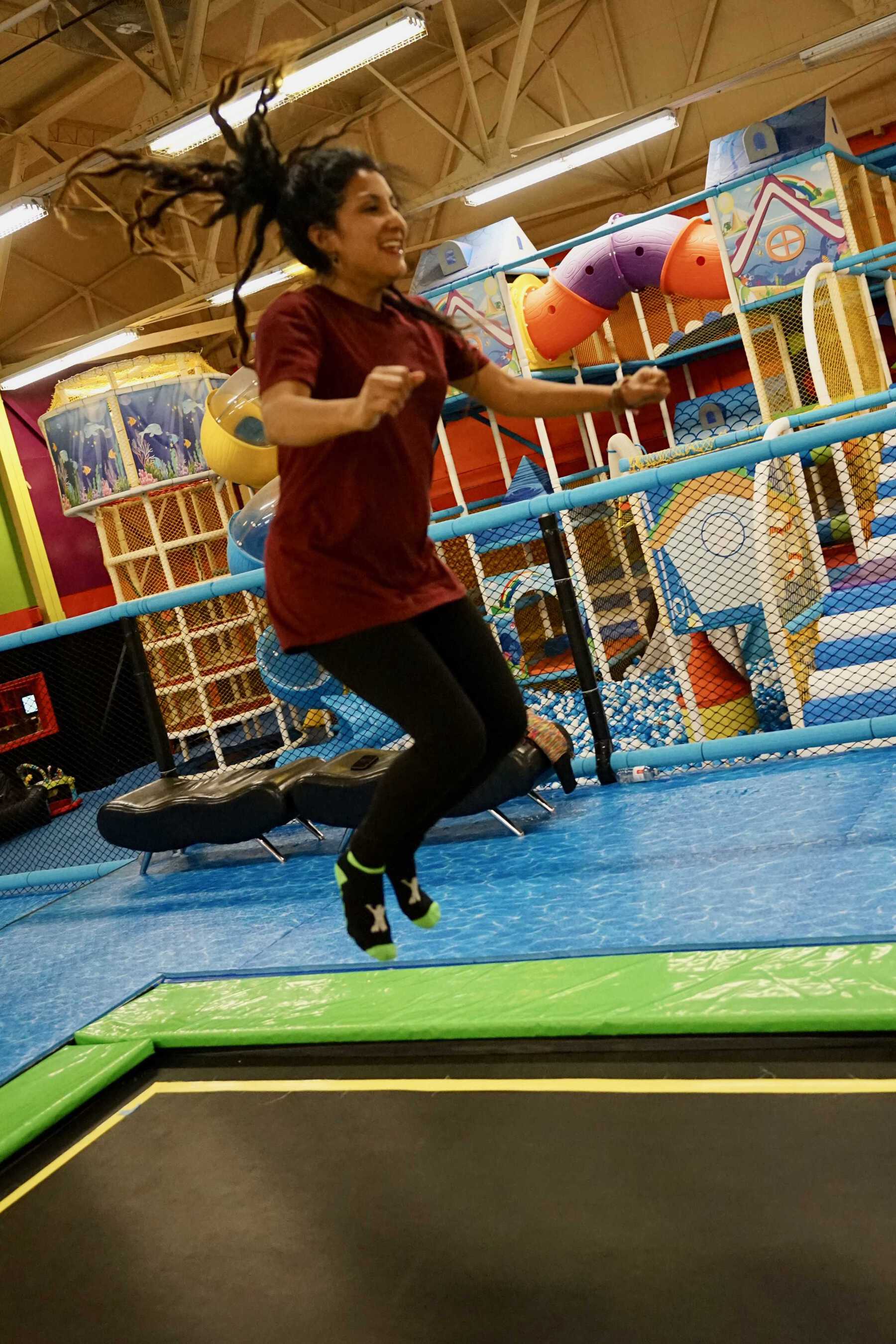 Woman smiling and jumping on trampoline