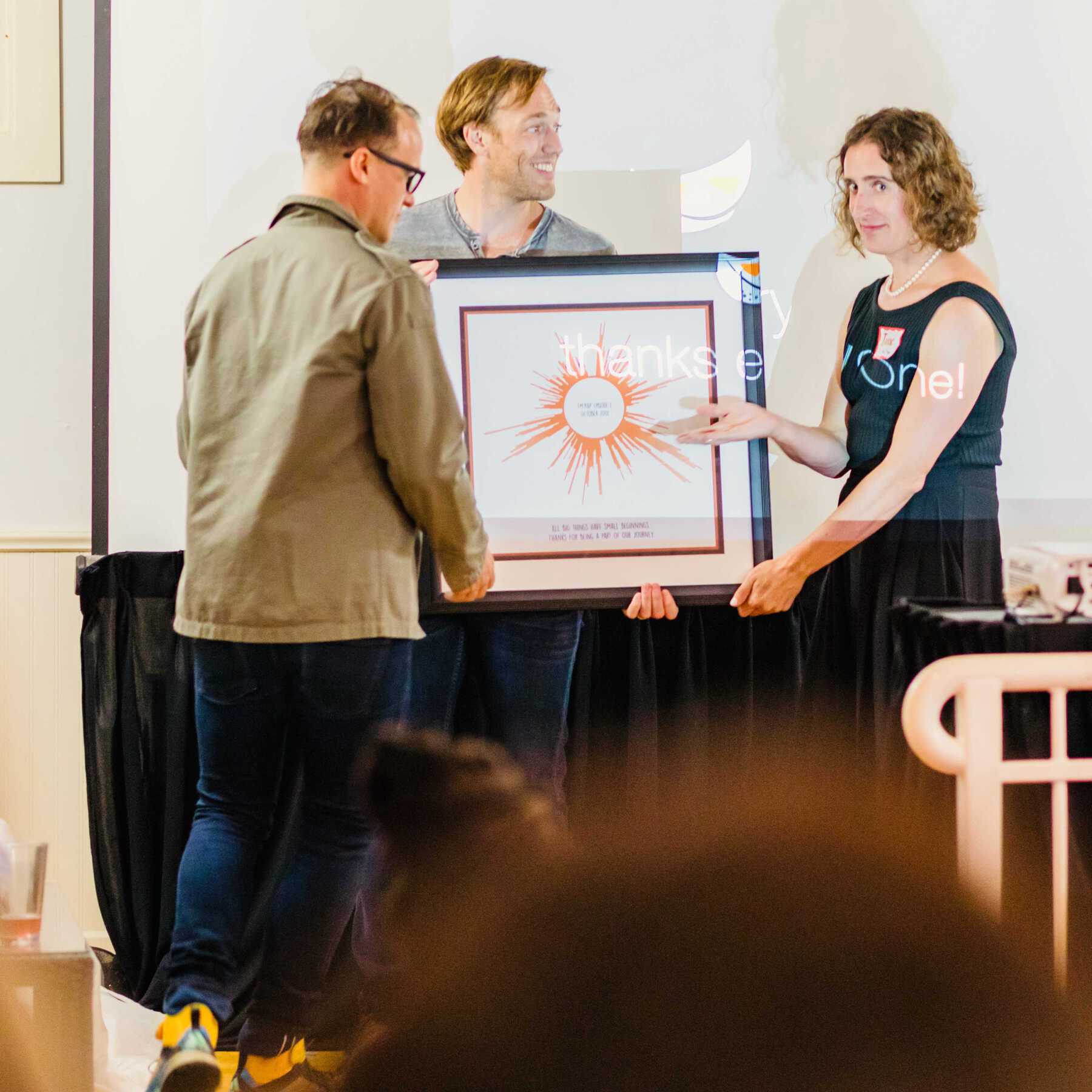People presenting framed artwork