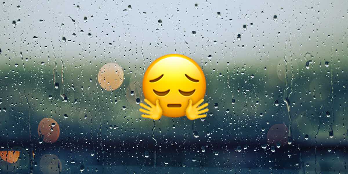 Emoji with sad face and hugging arms in front of rainy window