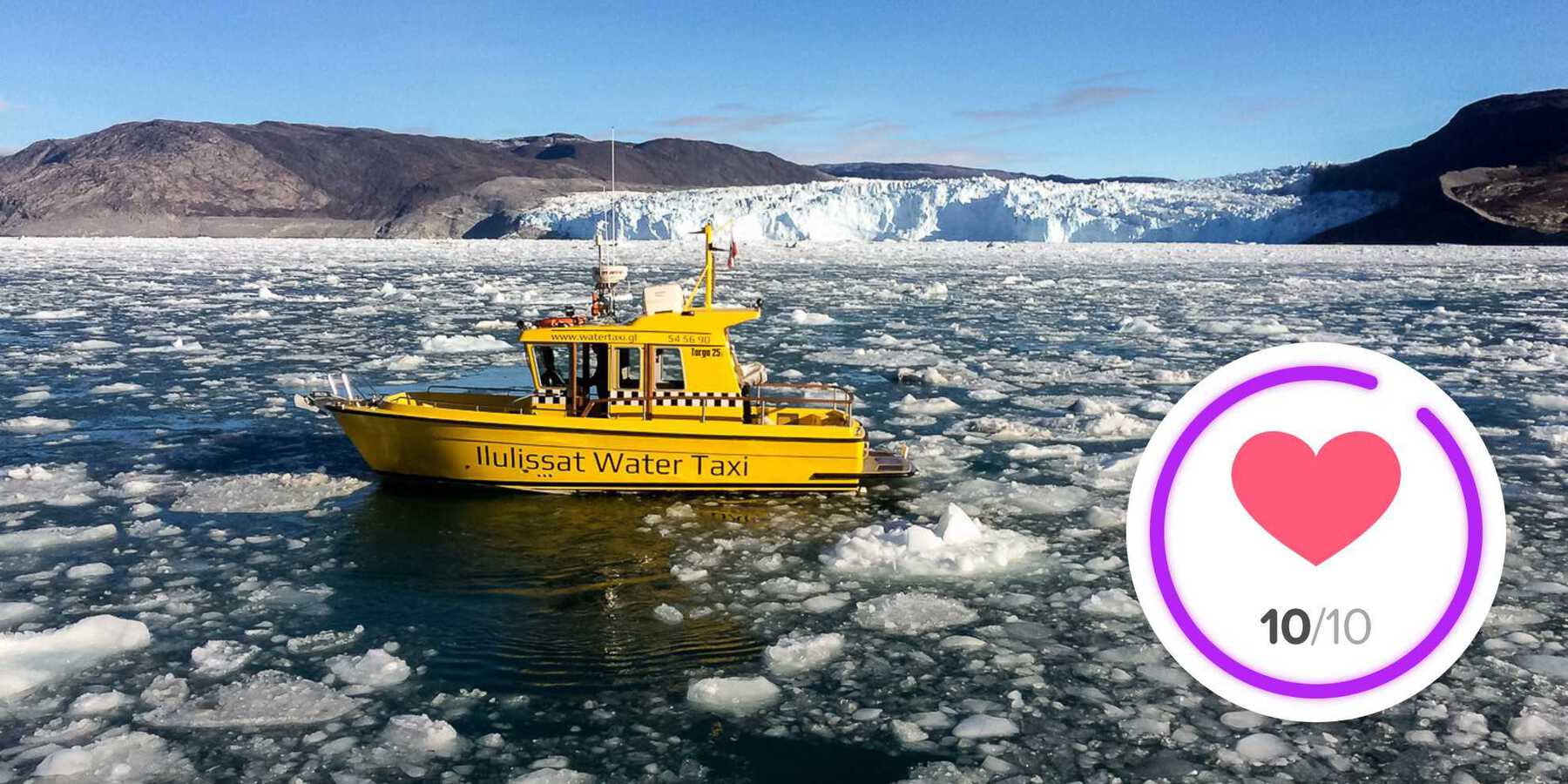 Small yellow boat with text Ilulissat Water Taxi in icy water