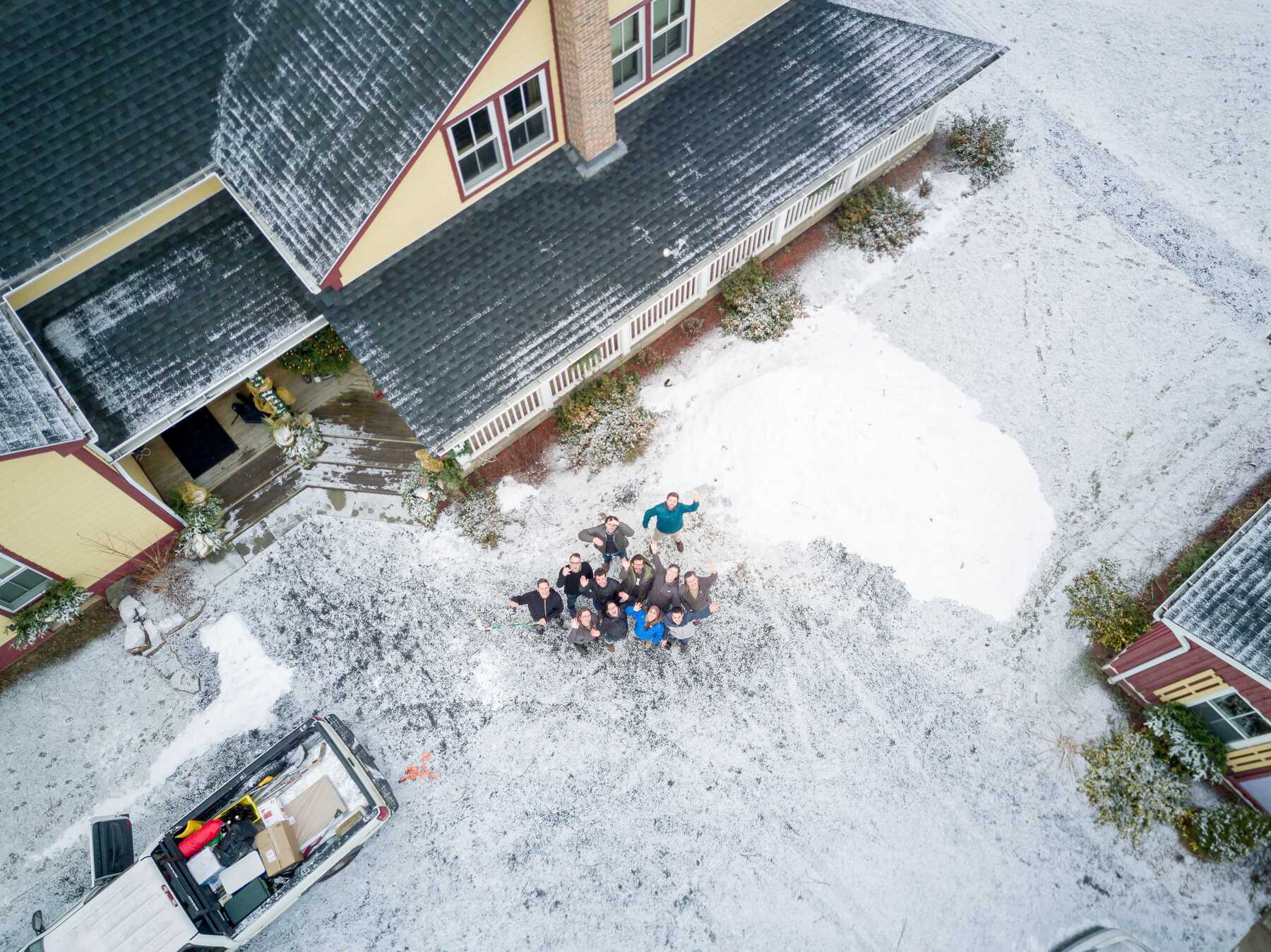 Group in snow looking up to drone taking photo