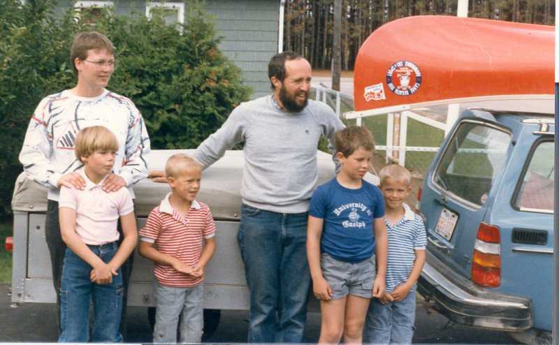 Family standing by trailer with canoe